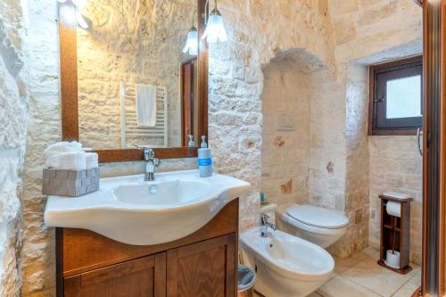 a bathroom with a sink and a toilet at I Trulli di Dona Filomena in Selva di Fasano