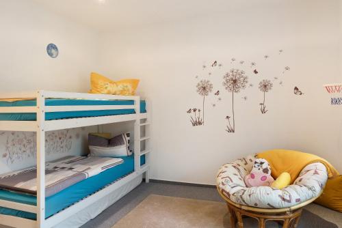 a childs room with a bunk bed and a chair at Haus Mari in Gommern