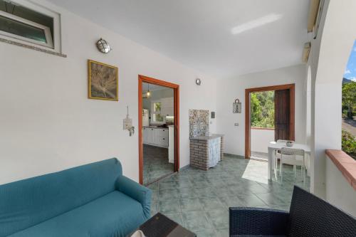 a living room with a blue couch and a kitchen at Buggerru Hugo House in Buggerru