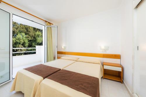 a bedroom with a bed and a large window at Apartament Massanet ba in Canyamel
