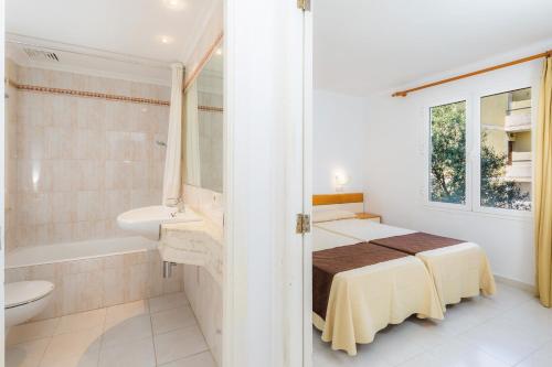 a bedroom with a bed and a bath tub and a sink at Apartament Massanet ba in Canyamel