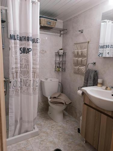 a bathroom with a toilet and a shower curtain at Thea Home Rhodes Pastida in Pastida