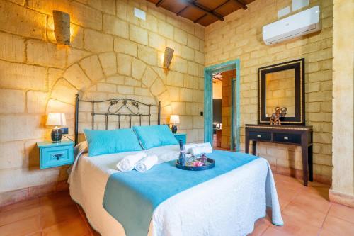 a bedroom with a bed with towels on it at Casa Rural Carmo in Carmona