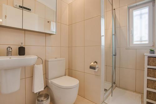 a bathroom with a toilet and a sink and a shower at Villa Sagres in Portimão