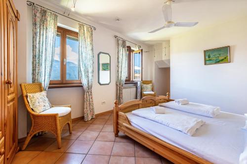 a bedroom with two beds and a chair at Appartment Capri in Tignale