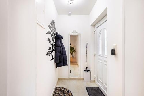 a hallway with white walls and a black coat hanging on the wall at Hochwertige Ferienwohnung in Lübeck