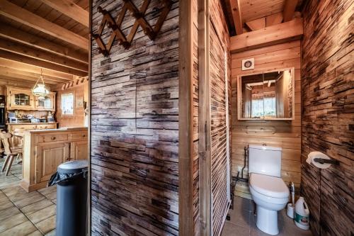 a bathroom with a toilet in a log cabin at Chalet 6p Classique - L'ourson in Verchaix