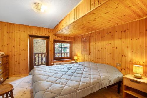 a bedroom with a large bed in a room with wooden walls at Maison Tillier Valtournenche in Valtournenche