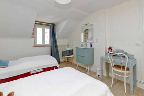 a bedroom with two beds and a desk at La Maison de Port Lin in Le Croisic