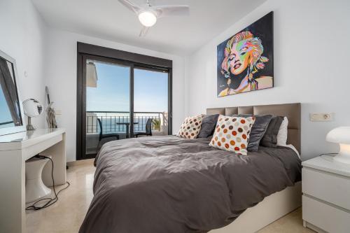 a bedroom with a bed and a desk and a window at Roya Vistamar in Torrox Costa