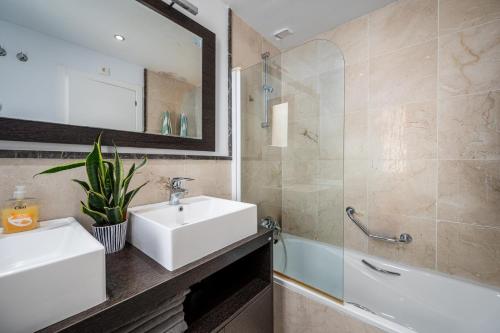 a bathroom with a sink and a mirror and a tub at Roya Vistamar in Torrox Costa