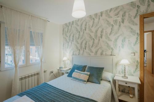 a bedroom with a bed with blue pillows at Rodrigo in Palencia