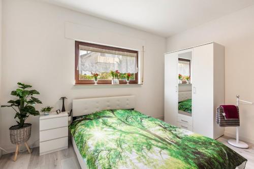 a bedroom with a bed and a window with plants at Haus Sonnenschein Bad Säckingen in Bad Säckingen