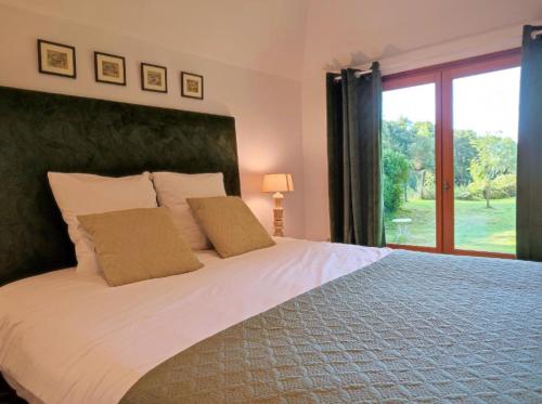 a bedroom with a large bed with a large window at Gîte Le Clos aux Cerises in Eu