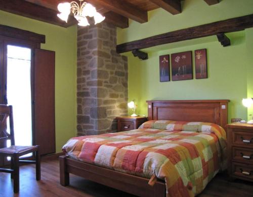 a bedroom with a bed and a stone wall at Casa Rural Enarakabi in Zunzarren