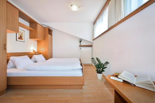 a bedroom with a bed and a desk with a book at Alpenchalet Niederkofler Isabella in San Giovanni in Val Aurina