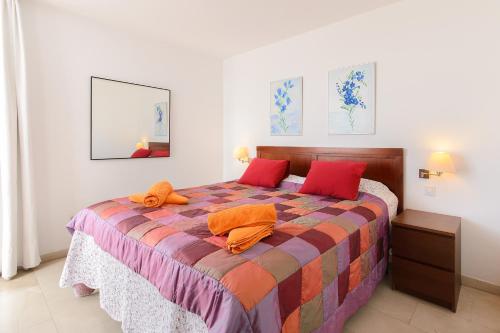 a bedroom with a large bed with red pillows at Luis iii in Puerto del Carmen