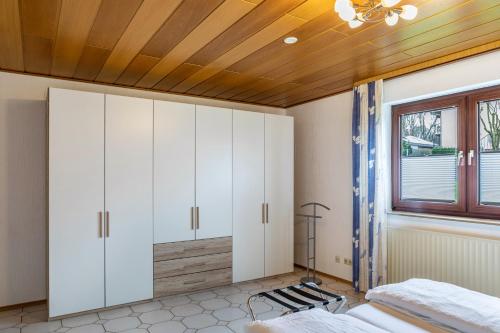 a bedroom with white cabinets and a wooden ceiling at Haus am Twistesee in Wetterburg