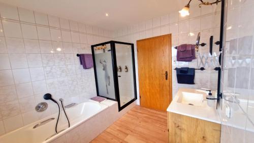 a bathroom with a tub and a sink and a shower at Haus am Twistesee in Wetterburg