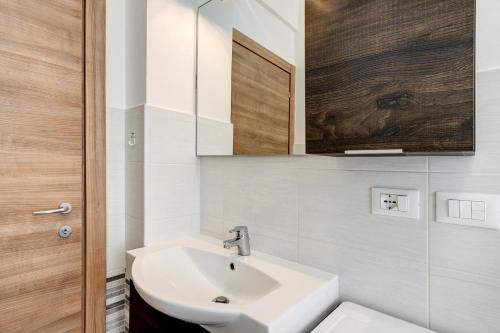 a white bathroom with a sink and a mirror at Loano Home in Loano