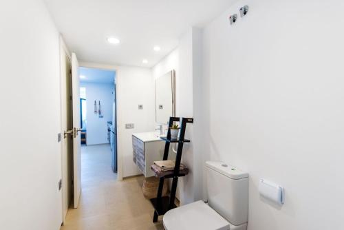 a white bathroom with a toilet and a sink at Beach Pearl Cala de Mijas in Mijas