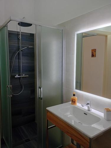 a bathroom with a sink and a shower with a glass door at Maison d'O in Otranto