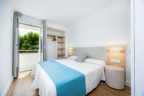 a bedroom with a large bed and a large window at Apartament Massanet 1b in Canyamel