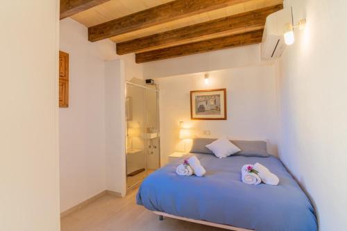 a bedroom with a blue bed with two pillows on it at Maca Sol in Campanet