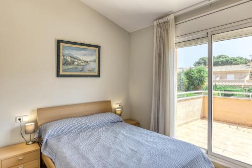a bedroom with a bed and a large window at Pinamar casa con piscina in L'Escala