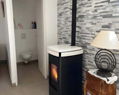 a black and white stove in a room with a lamp at Gite L'atelier De Théophile in Peltre