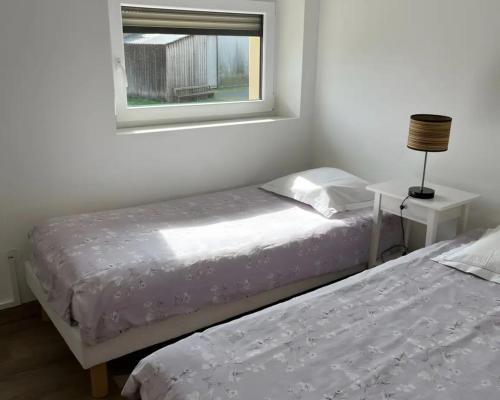 two twin beds in a room with a window at Gite L'atelier De Théophile in Peltre