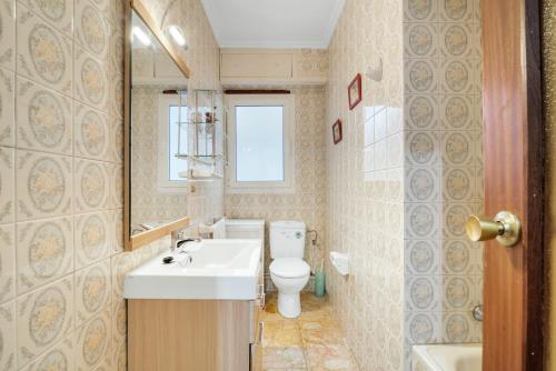 a bathroom with a white sink and a toilet at Paseo el Saladar in Denia