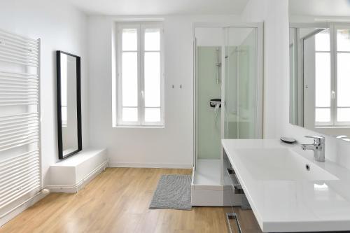 a white bathroom with a sink and a mirror at La Pointe Du Crotoy in Le Crotoy