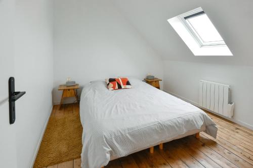 a bed in a white room with a window at La Pointe Du Crotoy in Le Crotoy