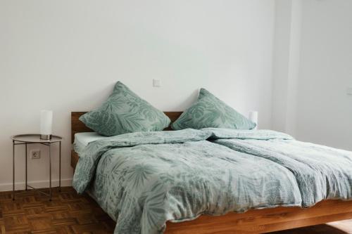 a bedroom with a bed with green blankets and pillows at Ferienwohnung Schwalbenflug in Naumburg