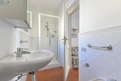 a white bathroom with a sink and a shower at Casa Ebaté in Chiessi