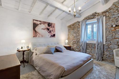 a bedroom with a large bed and a stone wall at Casa Collicello relax in Camaiore