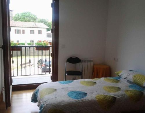 ein Schlafzimmer mit Bett und Blick auf einen Balkon in der Unterkunft Ultzama in Iráizoz