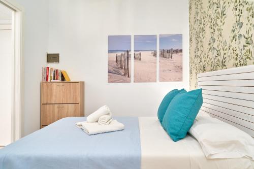 a bedroom with a bed with blue and white pillows at Apartamento Gondolas Costa Tropical in Almuñécar