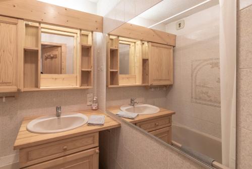 a bathroom with two sinks and a tub at L’Edelweiss Pied des Pistes in Morillon