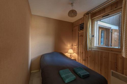 a small bedroom with a bed and a window at L’Edelweiss Pied des Pistes in Morillon
