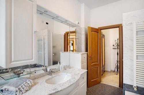 a white bathroom with a sink and a mirror at Alassio Holiday in Alassio