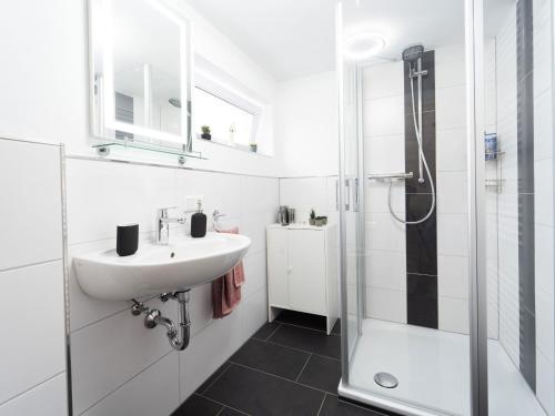 a white bathroom with a sink and a shower at Ferienwohnung Sunny in Schmallenberg