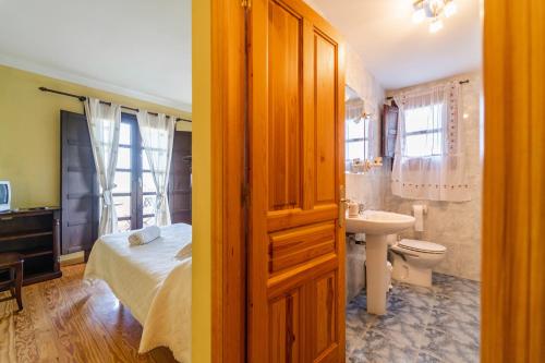 a bathroom with a bed and a sink and a toilet at Casa Rural De Cabrera in Urrez