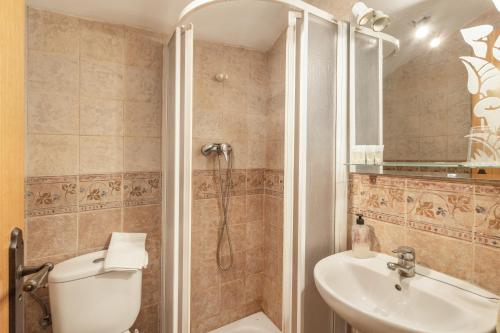 a bathroom with a shower and a toilet and a sink at El Tejado in Maluenda