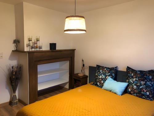 a bedroom with an orange bed and a fireplace at Gite De Ségonzac in Villecomtal
