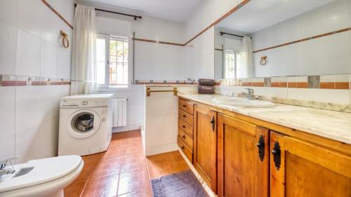 a bathroom with a sink and a washing machine at Costacabana - Villa Alba in Lloret de Mar