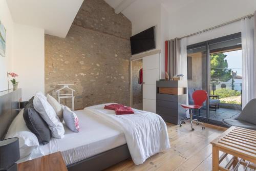 a bedroom with a bed and a large window at Bocal De Bages - Chez l'habitant in Bages