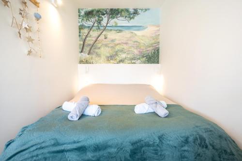 two towels on a bed in a room with a painting at La pause iodée Studio -grand balcon in Concarneau
