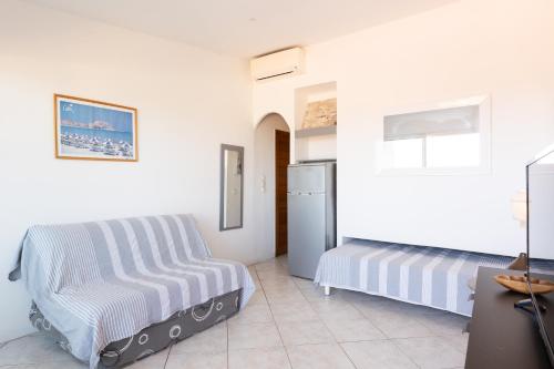 a white room with two beds and a refrigerator at Marina de Sant Ambroggio in Lumio